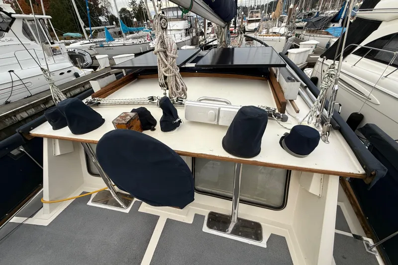  Yacht Photos Pics 1980 Nauticat Pilothouse sailboat deck with covered equipment and moored yachts in background.