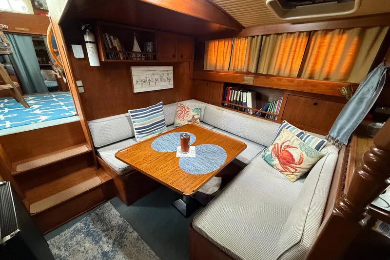  Yacht Photos Pics Cozy 1980 Nauticat Pilothouse interior with cushioned seating, wooden table, and nautical decor.