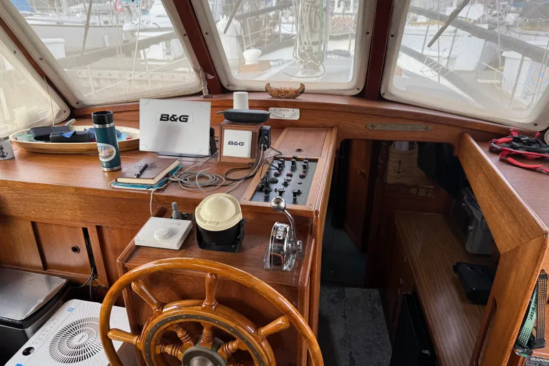  Yacht Photos Pics 1980 Nauticat Pilothouse interior with wooden helm, navigation equipment, and panoramic windows.