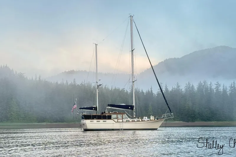  Yacht Photos Pics 1980 Nauticat Pilothouse sailboat on misty lake with forested mountains in background.