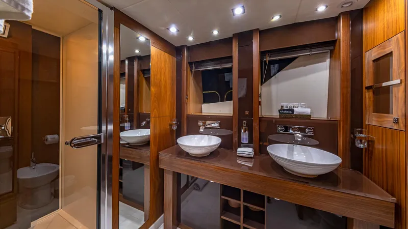 Emrys Yacht Photos Pics Luxurious bathroom interior of 2010 Sunseeker Flybridge yacht with dual sinks and wooden accents.