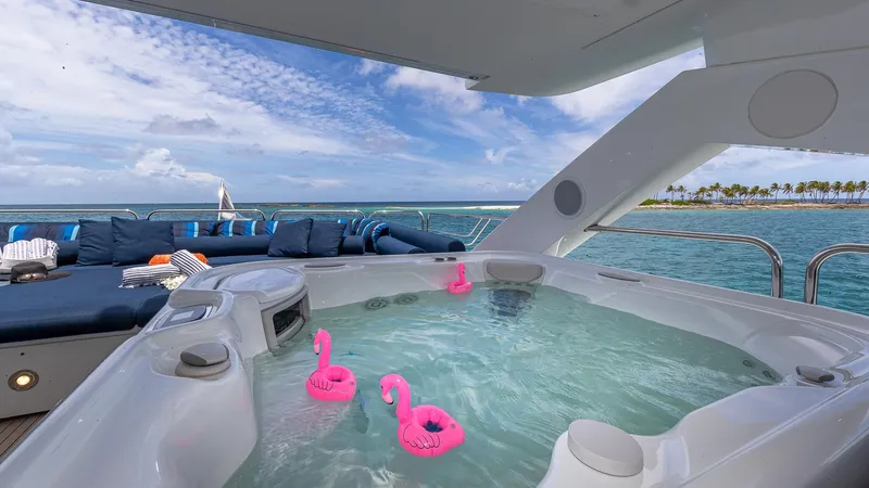 Emrys Yacht Photos Pics Luxurious Sunseeker Flybridge yacht with jacuzzi and ocean view, featuring pink flamingo floats.