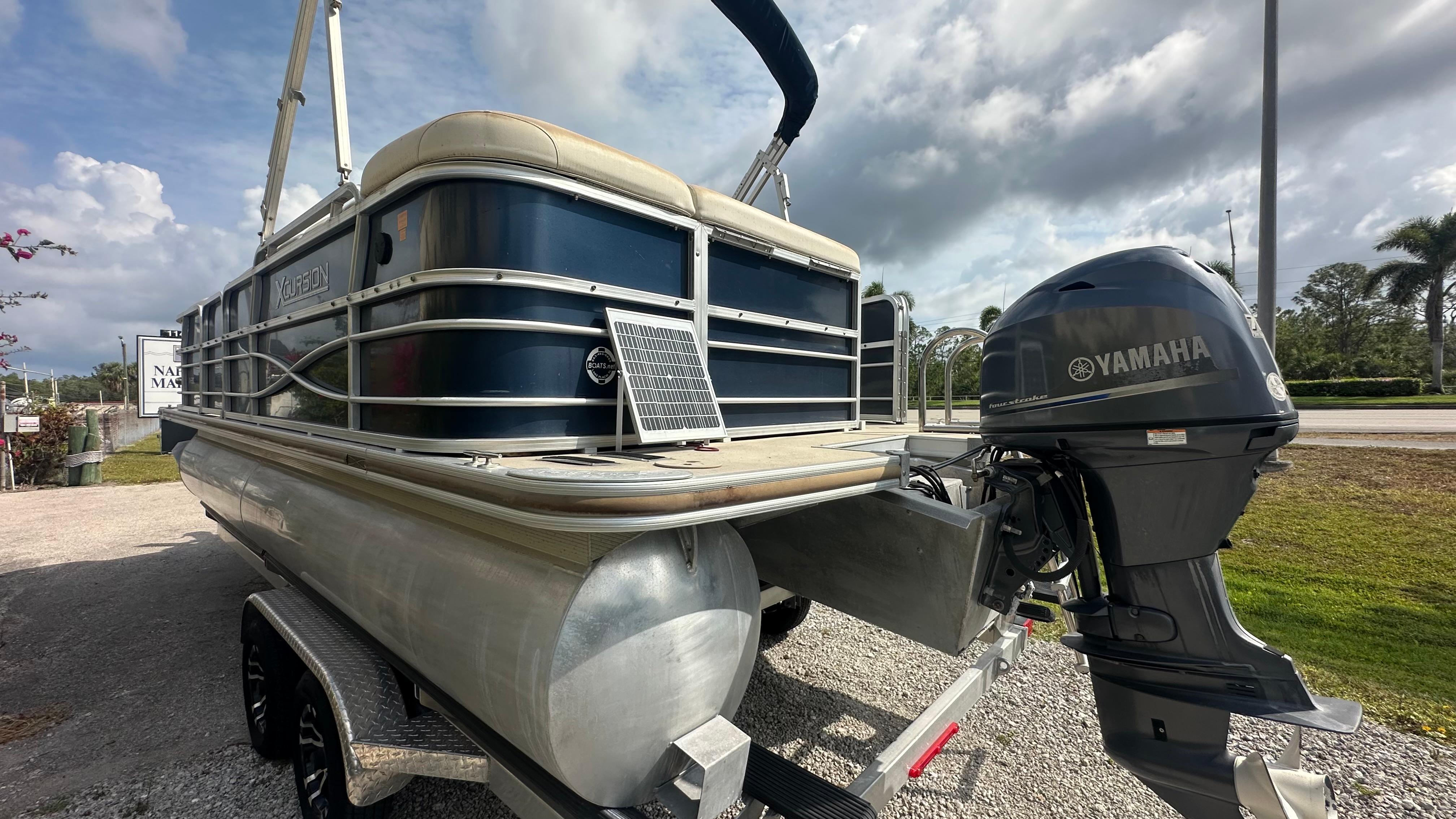 2012 Xcursion X21C pontoon boat with Yamaha outboard motor, parked on a trailer.