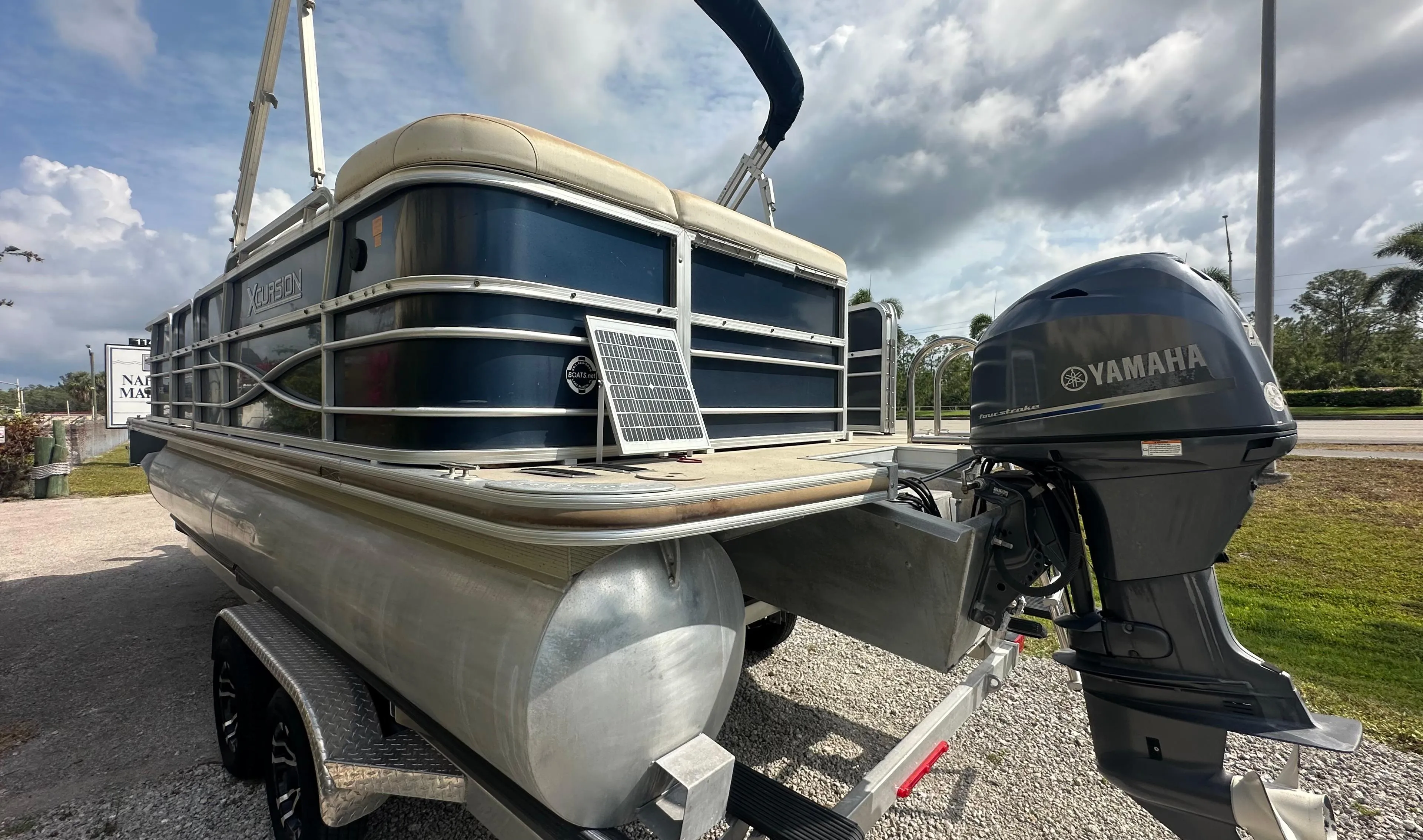 2012 Xcursion X21C pontoon boat with Yamaha outboard motor, parked on a trailer.
