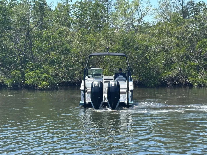  Yacht Photos Pics 2022 Cobalt R8 Outboard boat navigating through a lush, green waterway.