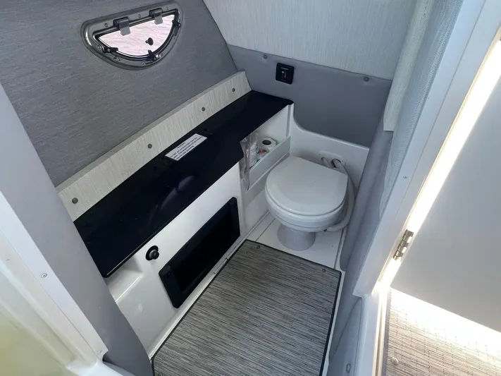  Yacht Photos Pics 2022 Cobalt R8 Outboard boat interior bathroom with toilet and window.