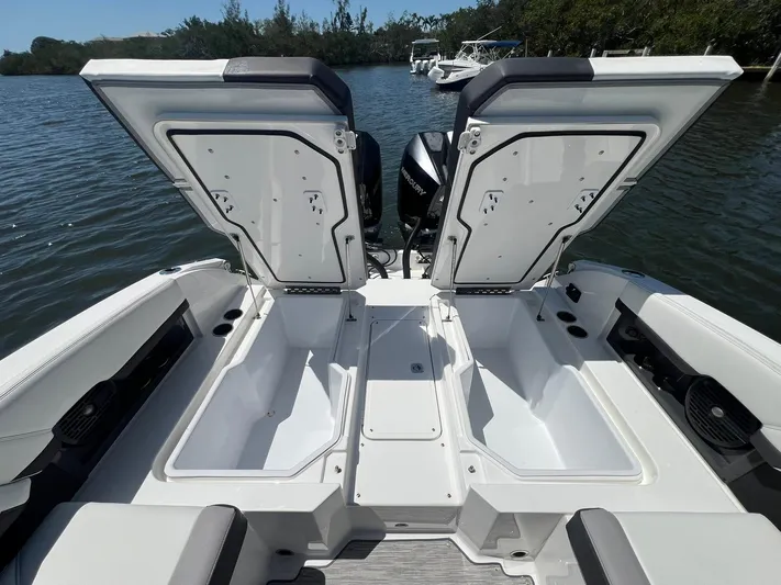  Yacht Photos Pics 2022 Cobalt R8 Outboard boat with open storage compartments on a calm lake.