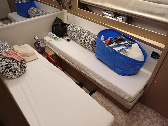  Yacht Photos Pics Interior of a 2020 Prestige 590 yacht cabin with twin beds and storage items.