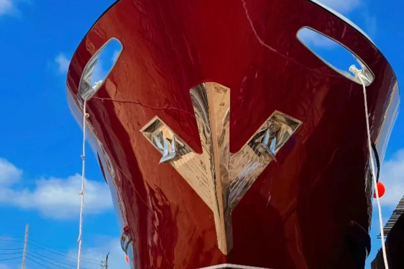 M/y Oxygen Yacht Photos Pics 2025 47m Expedition Yacht with sleek red hull against blue sky.