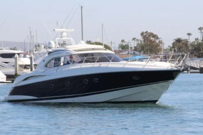 D Yacht Photos Pics Sunseeker Predator 60 yacht, 2000 model, cruising in a marina with other boats.