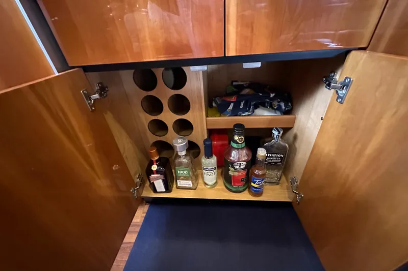 D Yacht Photos Pics Liquor cabinet inside a 2000 Sunseeker Predator 60 yacht, featuring various bottles and storage.
