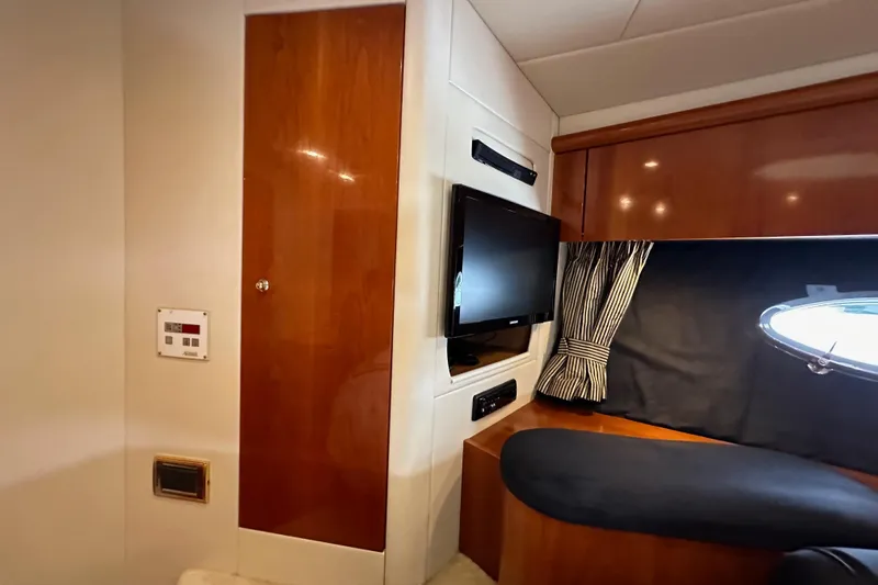 D Yacht Photos Pics Interior of 2000 Sunseeker Predator 60 yacht with TV, wood paneling, and porthole.