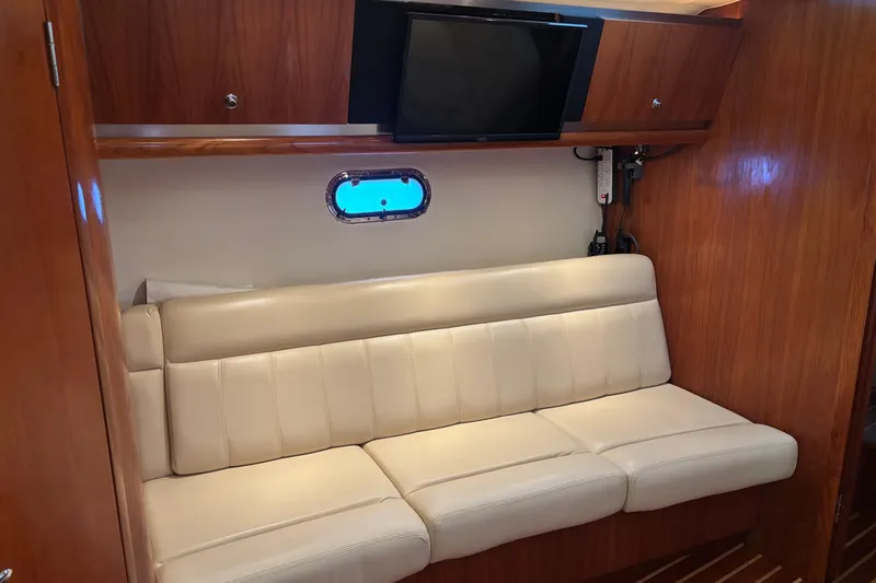 Salina Yacht Photos Pics 2004 Tiara Yachts 3600 Sovran interior with cream leather sofa and wall-mounted TV.