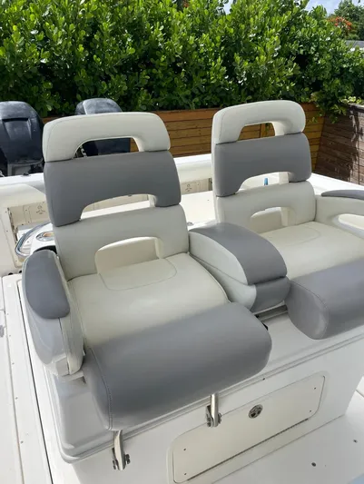  Yacht Photos Pics 2005 Boston Whaler 320 Outrage boat seats, gray and white, with lush greenery in the background.