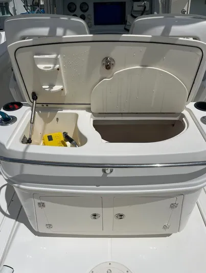  Yacht Photos Pics 2005 Boston Whaler 320 Outrage boat with open storage compartment and control panel.