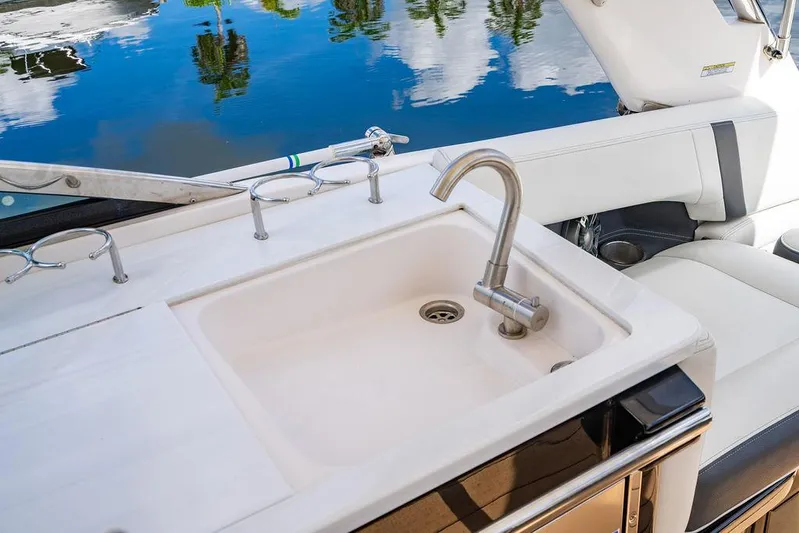 Dreamaker Yacht Photos Pics 2021 Regal 29 OBX boat sink and seating area with water view.