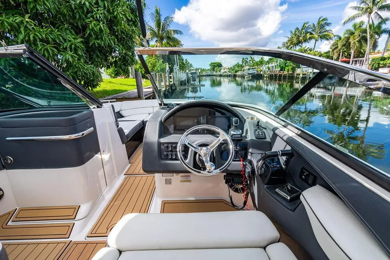 Dreamaker Yacht Photos Pics 2021 Regal 29 OBX boat interior with steering wheel, docked by a scenic canal.