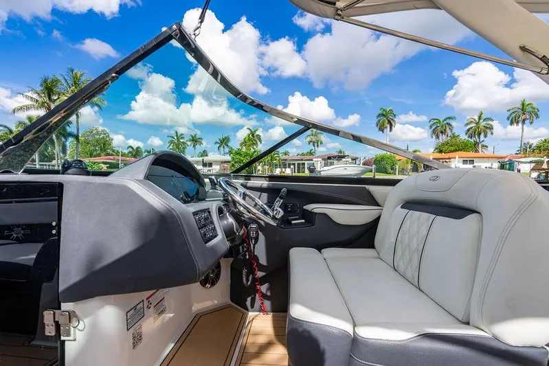 Dreamaker Yacht Photos Pics 2021 Regal 29 OBX boat interior with luxurious seating and modern dashboard, under a sunny sky.