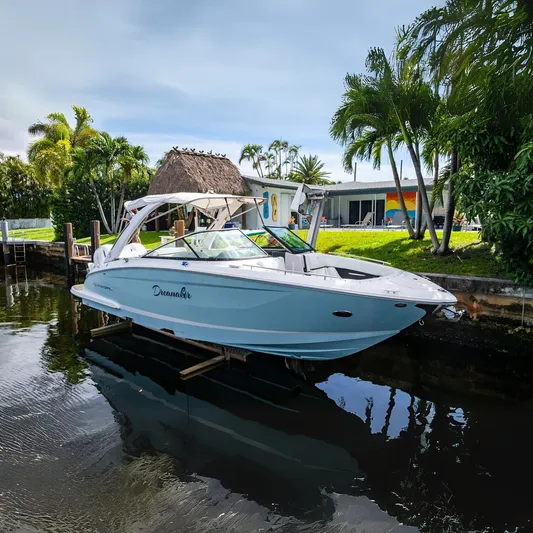Dreamaker Yacht Photos Pics 2021 Regal 29 OBX boat docked by a tropical waterfront home.