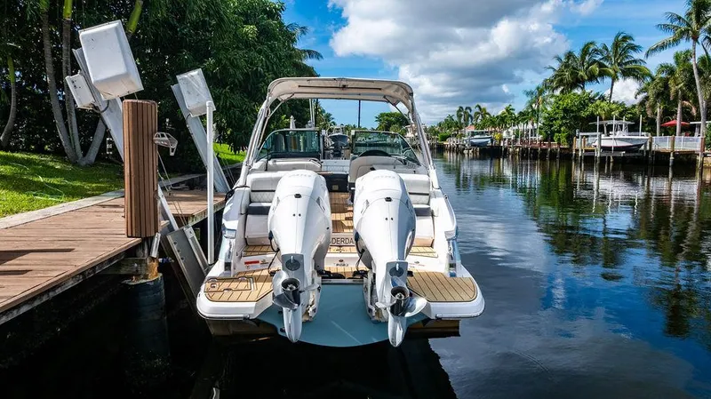 Dreamaker Yacht Photos Pics 2021 Regal 29 OBX boat docked on a scenic canal with palm trees.