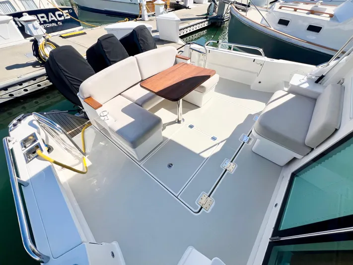 Risk & Reward Yacht Photos Pics 2022 Back Cove 39O boat deck with seating and table, docked at marina.