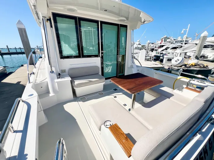 Risk & Reward Yacht Photos Pics 2022 Back Cove 39O yacht with spacious deck, seating, and table at marina.