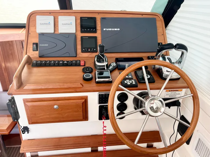 Risk & Reward Yacht Photos Pics Helm of 2022 Back Cove 39O with navigation equipment and wooden steering wheel.