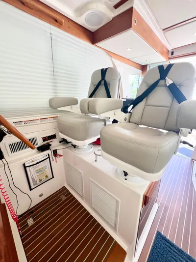 Risk & Reward Yacht Photos Pics 2022 Back Cove 39O helm seats with safety harnesses and wood flooring.