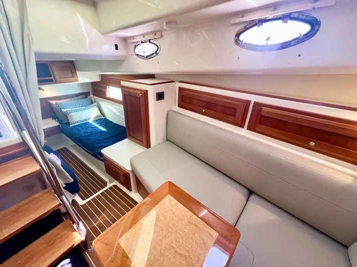 Risk & Reward Yacht Photos Pics 2022 Back Cove 39O interior with cozy seating, wooden accents, and a comfortable sleeping area.