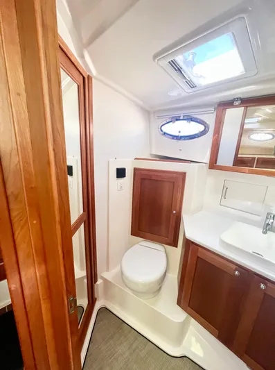 Risk & Reward Yacht Photos Pics 2022 Back Cove 39O yacht bathroom with wooden cabinetry and modern fixtures.