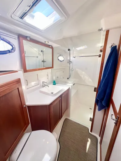 Risk & Reward Yacht Photos Pics 2022 Back Cove 39O yacht bathroom with modern fixtures and wooden cabinetry.