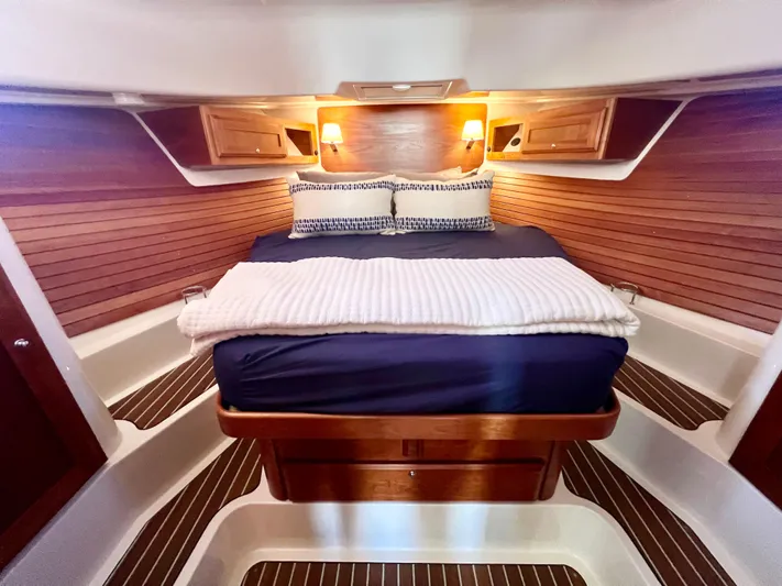 Risk & Reward Yacht Photos Pics Luxurious cabin interior of 2022 Back Cove 39O yacht with cozy bed and warm lighting.