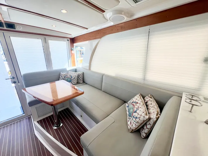 Risk & Reward Yacht Photos Pics Interior of 2022 Back Cove 39O yacht with modern seating and wooden table.