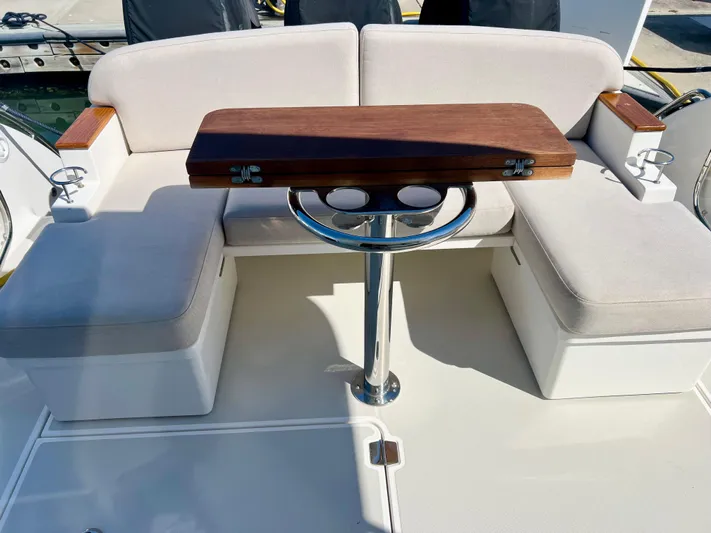 Risk & Reward Yacht Photos Pics 2022 Back Cove 39O boat seating area with wooden table and cup holders.