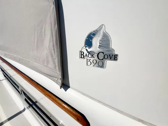 Risk & Reward Yacht Photos Pics 2022 Back Cove 39O yacht emblem on white hull with wooden trim.