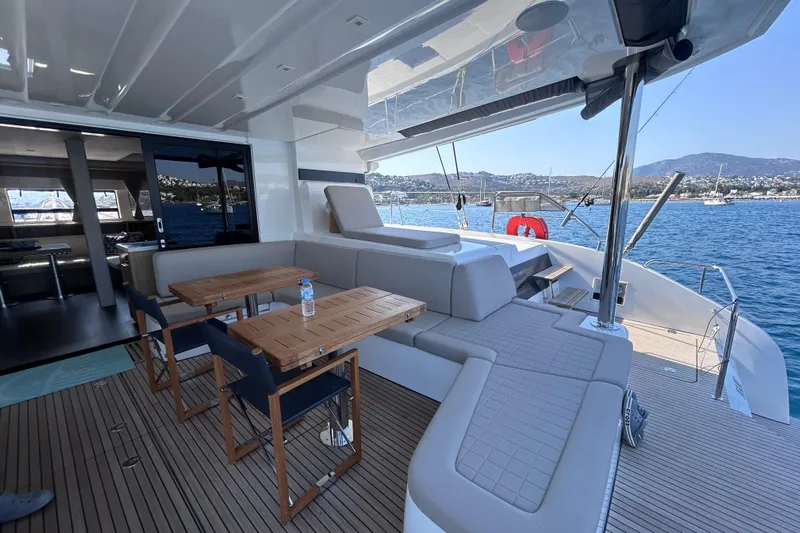 Nani Yacht Photos Pics Luxurious 2024 Lagoon 55 yacht with spacious deck and seating, overlooking serene waters.