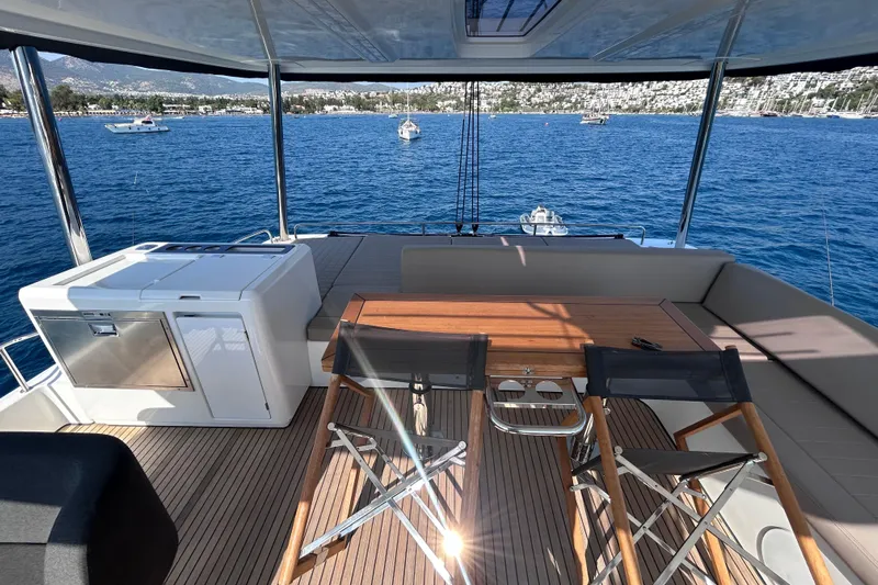 Nani Yacht Photos Pics Luxurious 2024 Lagoon 55 yacht deck with seating, table, and ocean view.