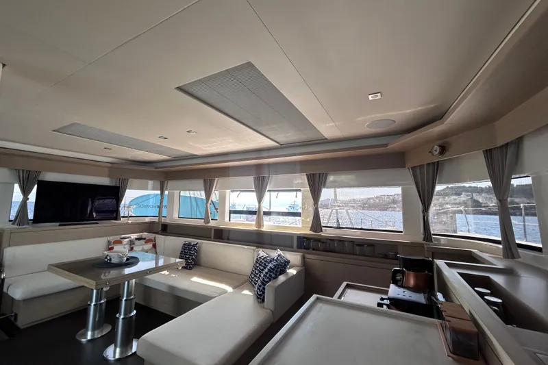 Nani Yacht Photos Pics Luxurious interior of 2024 Lagoon 55 yacht with panoramic windows and modern furnishings.