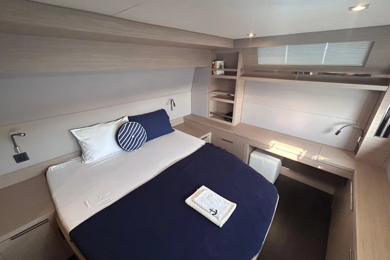 Nani Yacht Photos Pics 2024 Lagoon 55 yacht cabin with modern design, cozy bed, and ample storage.