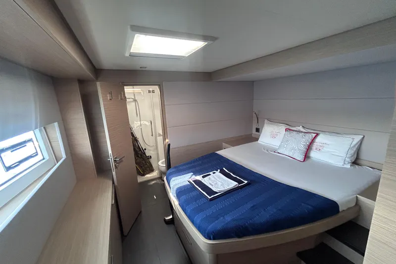 Nani Yacht Photos Pics Luxurious cabin interior of 2024 Lagoon 55 yacht with modern design and cozy bedding.