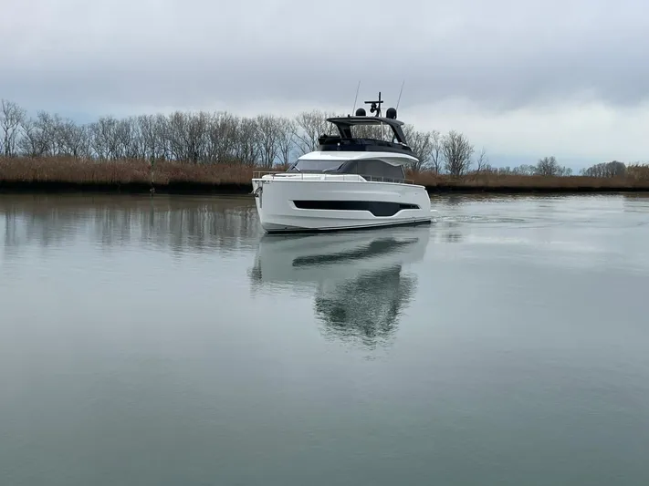  Yacht Photos Pics 2025 Cranchi 62 Sessantadue yacht on calm water, surrounded by trees.