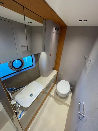  Yacht Photos Pics Luxurious bathroom in 2025 Cranchi 62 Sessantadue yacht with modern fixtures and porthole window.