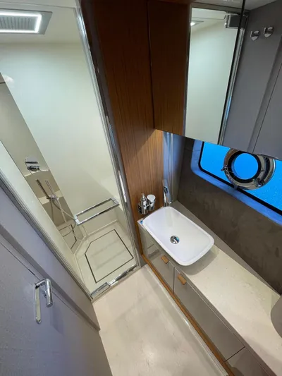  Yacht Photos Pics Luxurious bathroom in 2025 Cranchi 62 Sessantadue yacht with modern fixtures and porthole window.