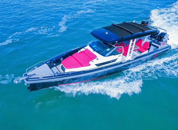  Yacht Photos Pics 2018 Axopar 37 Sun-Top boat cruising on blue water with red seating.