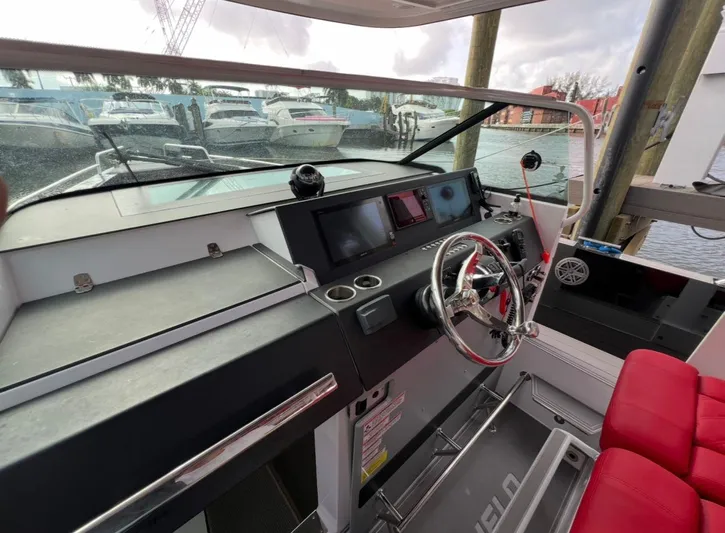  Yacht Photos Pics 2018 Axopar 37 Sun-Top boat helm with red seating and modern controls.
