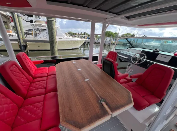  Yacht Photos Pics 2018 Axopar 37 Sun-Top boat interior with red seating and wooden table.