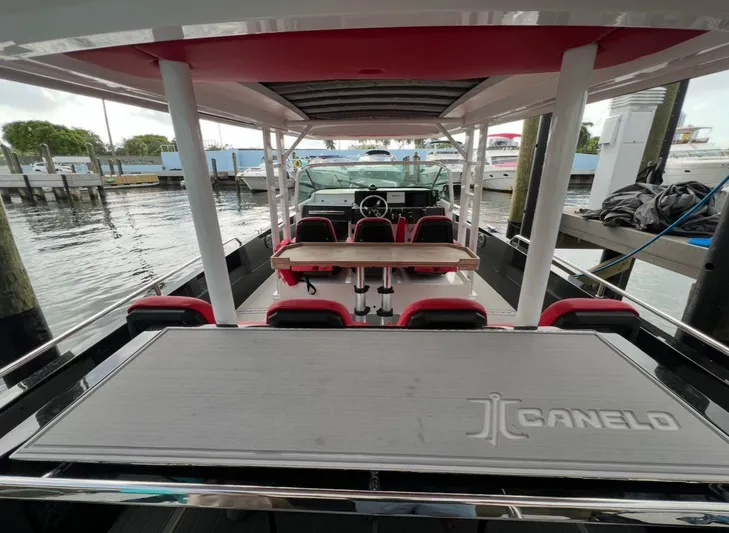  Yacht Photos Pics 2018 Axopar 37 Sun-Top boat interior with seating and table, docked at marina.