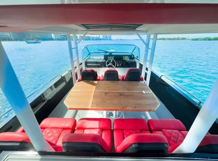  Yacht Photos Pics 2018 Axopar 37 Sun-Top boat with red seating and wooden table on open water.