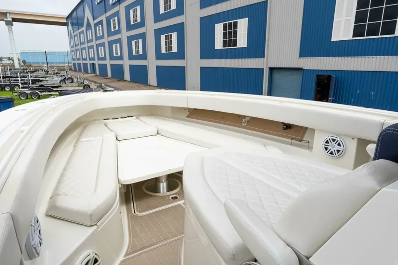  Yacht Photos Pics 2018 Hydra-Sports 4200 Siesta boat interior with white seating and table, docked near blue building.
