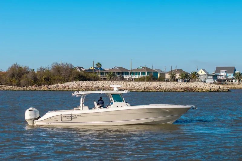  Yacht Photos Pics 2018 Hydra-Sports 4200 Siesta boat cruising on a sunny day near coastal homes.